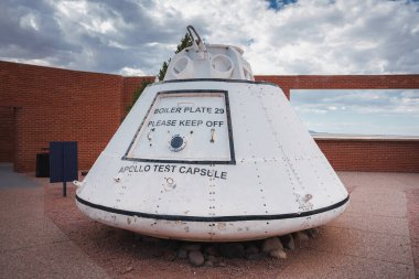 Explore a weathered Apollo test capsule labeled BOILER PLATE 29 outdoors in Arizona. Keep off sign, mechanical details, rocky base, and historic sky backdrop included. clipart