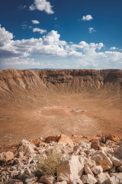 Impressive view of Meteor Crater, Barringer Crater in Arizona, USA. Vast, circular meteorite impact site with rocky terrain, clear blue sky, and sunlit crater walls. clipart