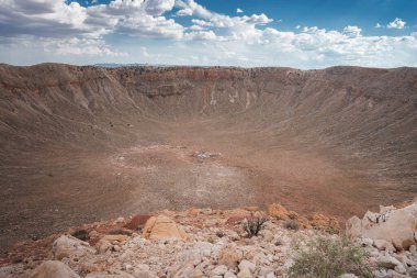 Explore the vast Meteor Crater in Arizona, USA. Marvel at its steep walls, rocky interior, and barren landscape, all captured in this striking photograph. clipart