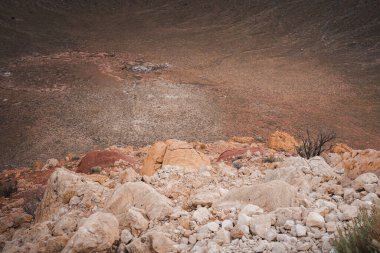 Discover the rocky landscape of Meteor Crater, Arizona, USA. Brown and beige boulders paint a rugged scene, showcasing erosions touch. Explore this iconic geological wonder. clipart