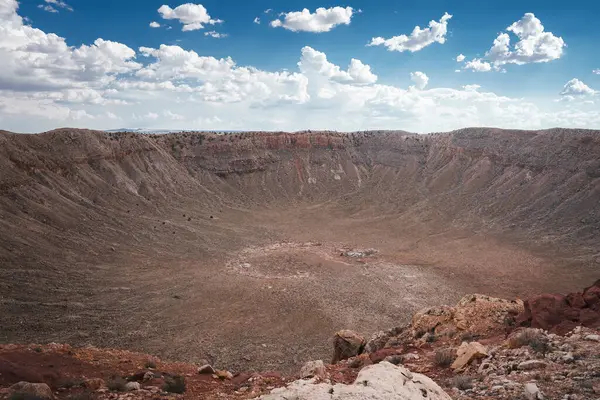 Arizona Çölü, ABD 'de Barringer Krateri' ni dayatıyor. Meteorit çarpma alanı kayalık duvarlar, döküntü dolu zemin ve parçalı bulutlu gökyüzünün altında engebeli kenar..