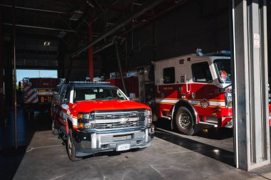 Colorado 'dan gelen kırmızı beyaz Chevrolet kamyonlu itfaiye garajı göreve hazır. Arka planda park etmiş itfaiye arabası var. Şehir ayarları.