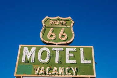 Barstow, ABD 'de mavi gökyüzüne karşı ikonik Route 66 tasarımı içeren klasik motel tabelası. Klasik 20. yüzyıl ortalarında nostaljik cazibeli yol kenarı reklamı..