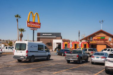 Explore a vibrant scene in Barstow, USA, along Route 66. The image showcases a McDonalds with a play area, a charming Barstow Station, and a bustling parking lot. clipart