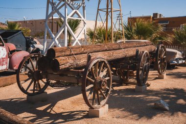 Explore this vintage Americana scene in Barstow, USA. An old wooden wagon, classic car, and historic structures capture the essence of Route 66 heritage. clipart
