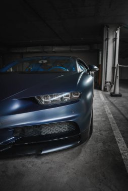 Lüks Bugatti Chiron yeraltı garajında metalik mavi. Karbon fiber detaylı parlak tasarım, modern LED farlar. Muhtemelen Los Angeles 'ın en uç noktasında..