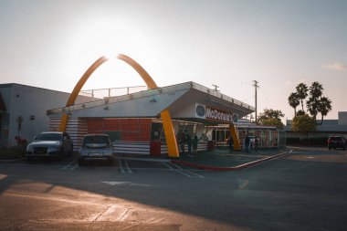 Güneş doğarken veya batarken geçmişe dönük tasarlanmış altın kemer logolu ikonik McDonalds restoranı. Los Angeles 'ta, klasik kırmızı, beyaz ve sarı renk düzeni ile biliniyor..