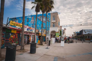 Venice Beach, Los Angeles 'ta canlı bir sokak sahnesi. Renkli dükkanları, graffiti sanatları ve eklektik duvar resimleri olan yaya dostu. Plaj kültürü ve sanatsal havanın eşsiz bir karışımı..