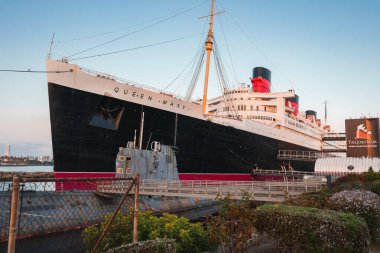 Emekli okyanus gemisi Queen Mary, şimdi Los Angeles, Kaliforniya yakınlarındaki Long Beach 'te bir otel ve turistik eğlence merkezi. Sıcak güneş ışığı ihtişamını ve tarihsel önemini sergiliyor..