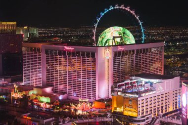 Las Vegas Bulvarı 'nın canlı gece manzarası. Flamingo Otel ve Kumarhanesi, LINQ, Yüksek Patinaj Gözlem Çarkı, neon ışıklar, şehir manzarası. Şehir gece hayatının özünü yakala..