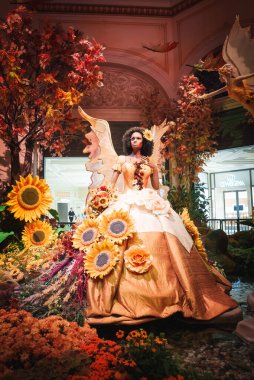 Las Vegas 'ta lüks bir ev ortamının zenginliğini hissedin. Çiçekli kostüm ve kanatları olan, sıcacık renklerle çevrili altın bir figüre hayran olun..