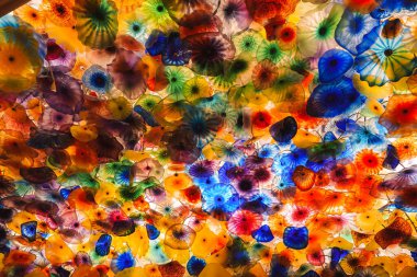 Colorful glass flowers by Dale Chihuly at the Bellagio Hotel in Las Vegas. Vibrant hues like yellow, orange, red, blue, and green create a stunning visual display. clipart