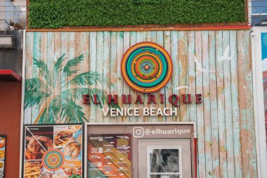 Venice Beach 'teki El Huarique restoranının ön cephesi. Yıpranmış ahşap kalaslar, canlı sanat eserleri, menü tahtası ve eklektik detaylar içeren kırsal bir cazibe..