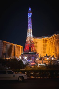 Vibrant Las Vegas Strip night scene white security vehicle, Eiffel Tower replica, lush greenery, opulent hotels glowing with lights. Captures citys lively essence. clipart