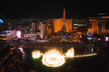 Aerial view of vibrant Las Vegas Strip at night with Bellagio fountains, Eiffel Tower replica at Paris Las Vegas Hotel, neon lights, and water shows. Iconic skyline in Vegas, Nevada. clipart