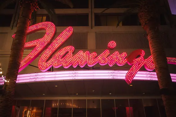 stock image Neon sign of Flamingo Las Vegas Hotel and Casino, vibrant pink and white lights on the Strip. Retro neon aesthetic with palm trees and lively atmosphere captured.