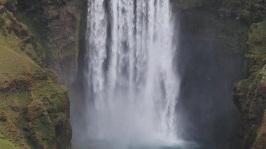 Gün batımında İzlanda 'nın etkileyici güzellikte doğası. Skogafoss şelalesi İzlanda 'nın ünlü bir doğal dönüm noktasıdır. Turistler ünlü şelale yakınlarında ata binerler..