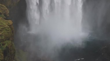 Gün batımında İzlanda 'nın etkileyici güzellikte doğası. Skogafoss şelalesi İzlanda 'nın ünlü bir doğal dönüm noktasıdır. Turistler ünlü şelale yakınlarında ata binerler..