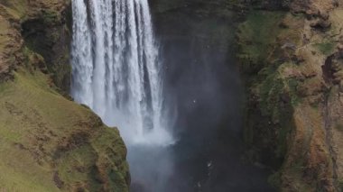 Gün batımında İzlanda 'nın etkileyici güzellikte doğası. Skogafoss şelalesi İzlanda 'nın ünlü bir doğal dönüm noktasıdır. Turistler ünlü şelale yakınlarında ata binerler..