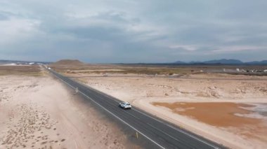 İzlanda 'da güzel bir yolda giden arazi aracı, arka planda seyahat. İzlanda 'dan gelen hava manzaralı bir yol gezisi. Yolun aşağısında ve dışında bir arabada.. 