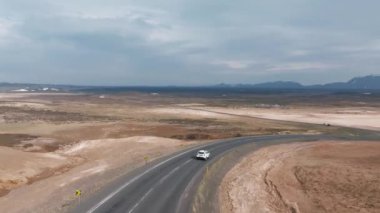 İzlanda 'da güzel bir yolda giden arazi aracı, arka planda seyahat. İzlanda 'dan gelen hava manzaralı bir yol gezisi. Yolun aşağısında ve dışında bir arabada.. 