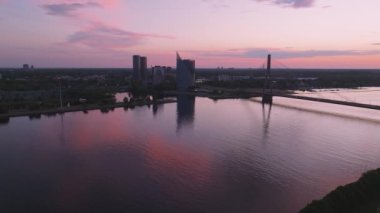 Riga kasabasında güzel bir gün batımı. Daugava nehrinin üzerinde mor alaca karanlık gökyüzü. Büyülü eski şehir Riga.