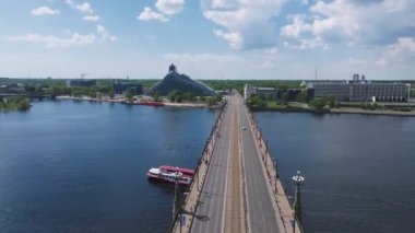 Riga Rimi Maratonu 2024. Maraton etkinliği sırasında şehirde koşan kalabalığın hava görüntüsü. Toprak setten başlayın ve insanlar Daugava nehrinden şehir merkezine doğru koşun..