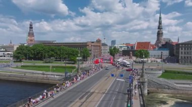 Riga Rimi Maratonu 2024. Maraton etkinliği sırasında şehirde koşan kalabalığın hava görüntüsü. Toprak setten başlayın ve insanlar Daugava nehrinden şehir merkezine doğru koşun..