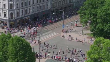 Riga Rimi Maratonu 2024. Maraton etkinliği sırasında şehirde koşan kalabalığın hava görüntüsü. Toprak setten başlayın ve insanlar Daugava nehrinden şehir merkezine doğru koşun..