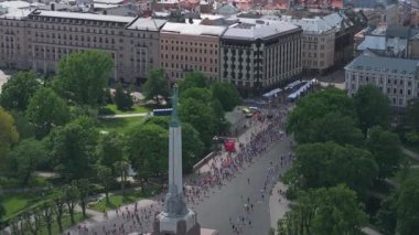 Riga Rimi Maratonu 2024. Maraton etkinliği sırasında şehirde koşan kalabalığın hava görüntüsü. Toprak setten başlayın ve insanlar Daugava nehrinden şehir merkezine doğru koşun..