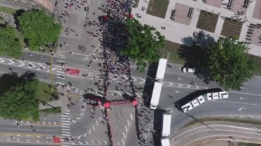 Riga Rimi Maratonu 2024. Maraton etkinliği sırasında şehirde koşan kalabalığın hava görüntüsü. Toprak setten başlayın ve insanlar Daugava nehrinden şehir merkezine doğru koşun..