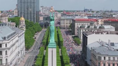 Riga Rimi Maratonu 2024. Maraton etkinliği sırasında şehirde koşan kalabalığın hava görüntüsü. Toprak setten başlayın ve insanlar Daugava nehrinden şehir merkezine doğru koşun..
