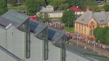 Riga Rimi Maratonu 2024. Maraton etkinliği sırasında şehirde koşan kalabalığın hava görüntüsü. Toprak setten başlayın ve insanlar Daugava nehrinden şehir merkezine doğru koşun..