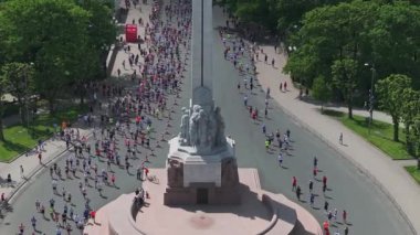 Riga Rimi Maratonu 2024. Maraton etkinliği sırasında şehirde koşan kalabalığın hava görüntüsü. Toprak setten başlayın ve insanlar Daugava nehrinden şehir merkezine doğru koşun..