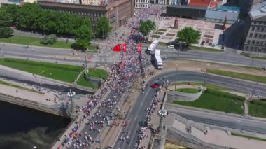 Riga Rimi Maratonu 2024. Maraton etkinliği sırasında şehirde koşan kalabalığın hava görüntüsü. Toprak setten başlayın ve insanlar Daugava nehrinden şehir merkezine doğru koşun..