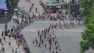 Riga Rimi Maratonu 2024. Maraton etkinliği sırasında şehirde koşan kalabalığın hava görüntüsü. Toprak setten başlayın ve insanlar Daugava nehrinden şehir merkezine doğru koşun..