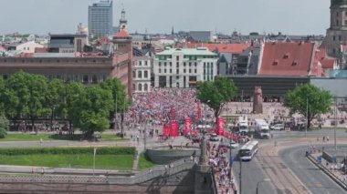 Riga Rimi Maratonu 2024. Maraton etkinliği sırasında şehirde koşan kalabalığın hava görüntüsü. Toprak setten başlayın ve insanlar Daugava nehrinden şehir merkezine doğru koşun..
