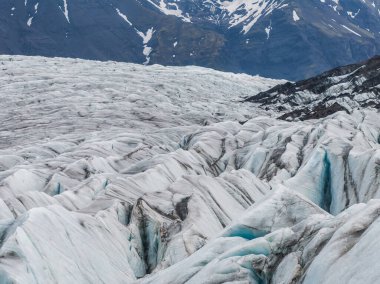 Bir İzlanda buzulunun göz kamaştırıcı yakın çekimi derin yarıklar ve güzel mavi buz sergiliyor. Karla kaplı buzullar İzlanda 'nın doğal güzelliklerini ön plana çıkarıyor..