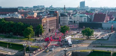 Riga Rimi Maratonu 2024 'te Letonya' nın Riga kentinin geleneksel Avrupa caddelerinde koşan katılımcıların enerji dolu havadan çekimleri.