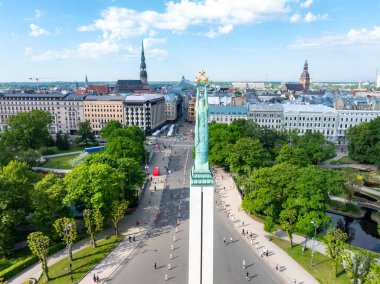 Letonya 'nın Riga kentindeki Özgürlük Anıtı' nın kuş bakışı görüntüsünde, üzerinde büyük bir parkla çevrili üç yıldızlı bir heykel bulunan uzun bir sütun bulunuyor..