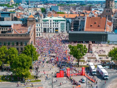 Maraton koşucularının enerjilerini yakalayan hava görüntüleri Letonya 'nın Riga kentindeki büyük bir meydanda toplandı. Avrupa mimari binaları ve bir heykel görülebilir.