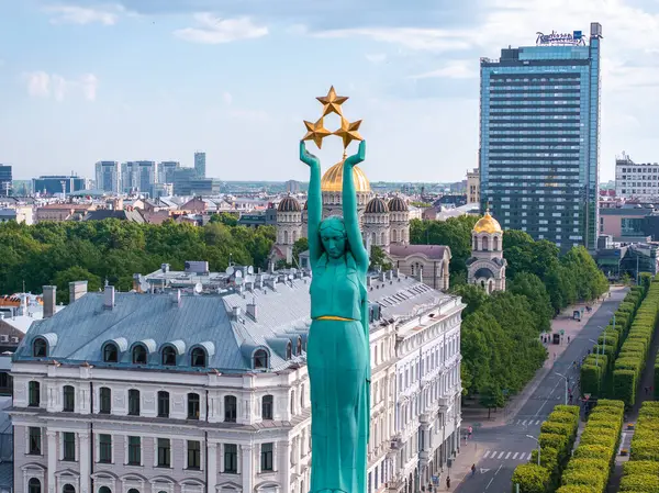 stock image Aerial view of the iconic Freedom Monument in Riga, Latvia, surrounded by buildings and trees. The city skyline is visible in the background, showcasing Latvian pride.