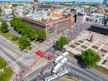 2024 Riga Rimi Maratonu 'nun bitiş çizgisindeki heyecanı gösteren hava çekimi. Görüntüde Riga Town Hall ve çevresindeki binalar yer alıyor..
