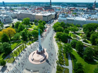 Riga, Letonya sokaklarında bir maratona katılan koşucular, merkez bir anıt ve eski ve yeni binaların bir karışımı etrafında büyük bir kalabalık toplandı..