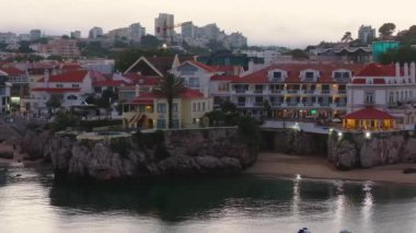 Portekiz 'in Cascais kasabası yakınlarındaki tropikal egzotik körfeze demirlemiş güzel, modern, aydınlatılmış lüks bir yatın fotokopi uzayı ile hava gecesi çekimleri.