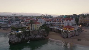 Portekiz 'in Cascais kasabası yakınlarındaki tropikal egzotik körfeze demirlemiş güzel, modern, aydınlatılmış lüks bir yatın fotokopi uzayı ile hava gecesi çekimleri.
