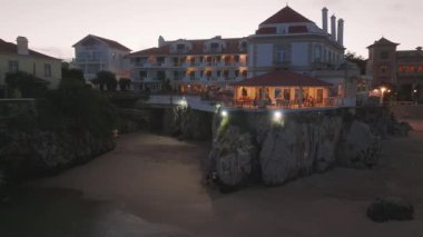 Portekiz 'in Cascais kasabası yakınlarındaki tropikal egzotik körfeze demirlemiş güzel, modern, aydınlatılmış lüks bir yatın fotokopi uzayı ile hava gecesi çekimleri.