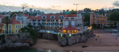 Cascais 'in hava panoramik günbatımı görüntüsü. Lizbon 'un 30 km batısında Portekiz' in Cascais bölgesinde. Praia da Rainha 'nın havadan görünüşü ve tarihi şehir merkezi Cascais, Portekiz