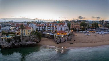 Cascais 'in hava panoramik günbatımı görüntüsü. Lizbon 'un 30 km batısında Portekiz' in Cascais bölgesinde. Praia da Rainha 'nın havadan görünüşü ve tarihi şehir merkezi Cascais, Portekiz
