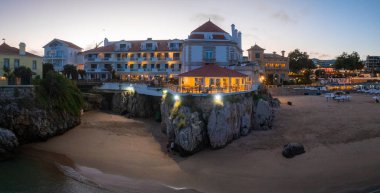 Cascais 'in hava panoramik günbatımı görüntüsü. Lizbon 'un 30 km batısında Portekiz' in Cascais bölgesinde. Praia da Rainha 'nın havadan görünüşü ve tarihi şehir merkezi Cascais, Portekiz